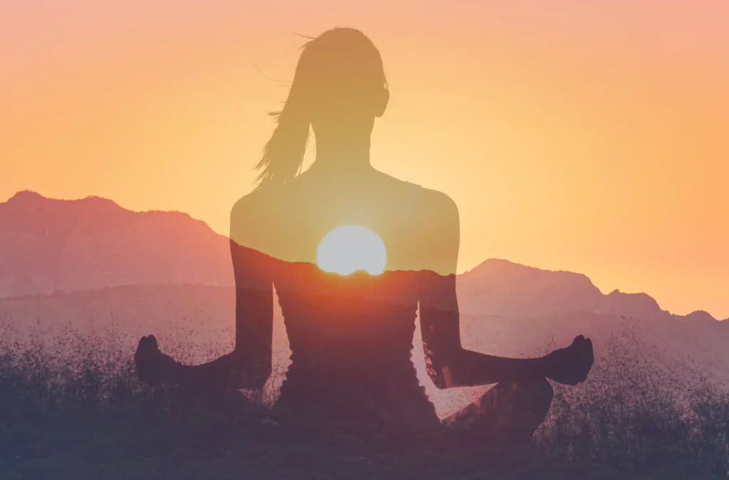 sitting in meditation against the sunrise